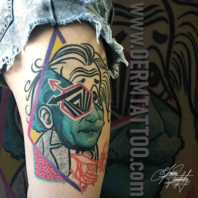 A colorful tattoo of a stylized face with geometric and abstract elements.