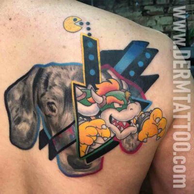 A colorful tattoo of a playful cartoon wolf inside the letter K on skin.