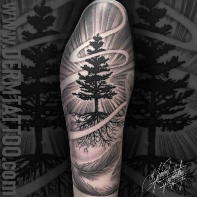 A black and gray tattoo of a tree with sun rays.