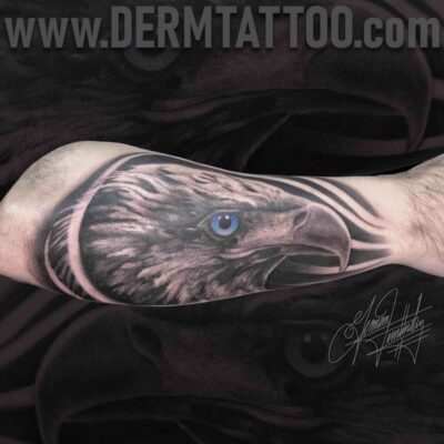 Realistic tattoo of an eagle's head on a forearm.