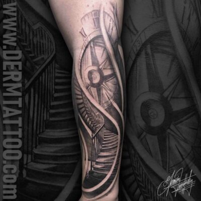 Black and grey tattoo of a compass with intricate shading on the arm.