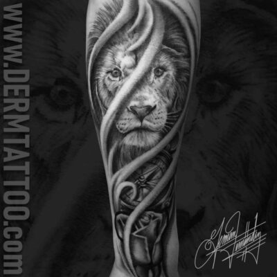 A detailed black and gray tattoo of a lion's face entwined with swirling, abstract shapes.